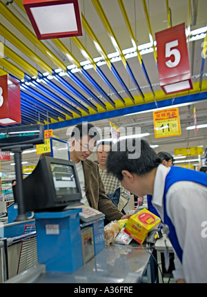 CHINA BEIJING Chinese men standing in checkout line at Wumart an upscale supermarket in Beijing Stock Photo