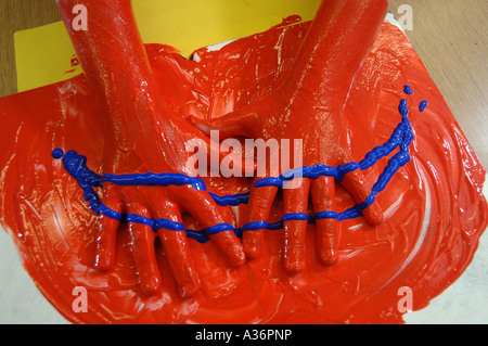 a childs hands covered in red and blue paint with a smile shape Stock Photo