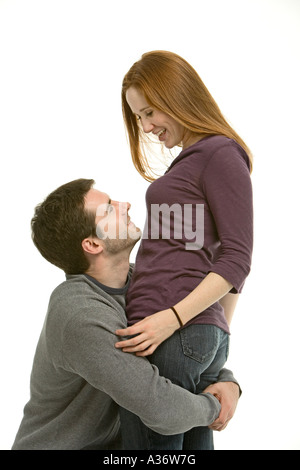 A young man lifts up his lovely red haired lover as they share a happy intimate moment Stock Photo