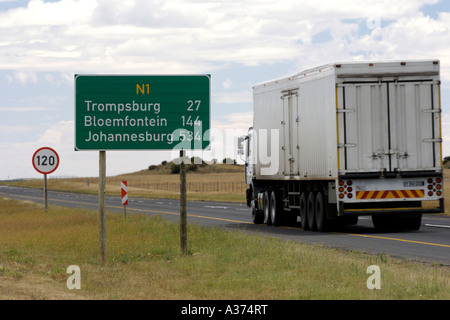 Distance sign board and a passing truck along the N1 highway in South Africa. Stock Photo