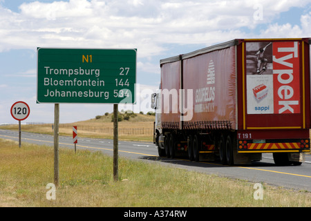 Distance sign board and a passing truck along the N1 highway in South Africa. Stock Photo