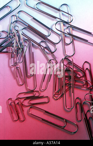 Paper Clips on red coloured background Stock Photo