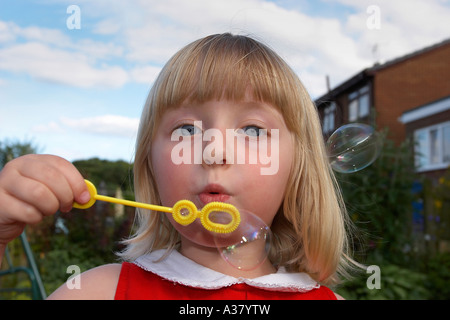 Blonde Haired Little Girl Blowing Bubbles Stock Photo
