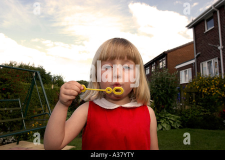 Blonde Haired Little Girl Blowing Bubbles Stock Photo