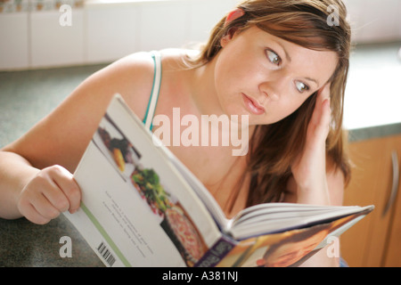 plump woman reading cookery book Stock Photo