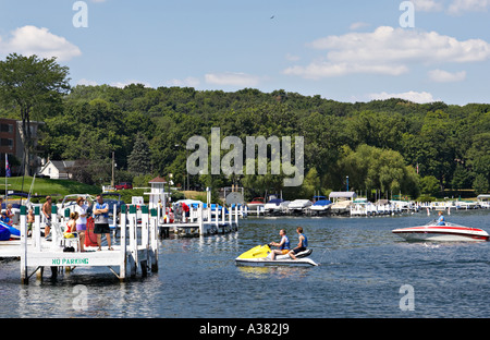 WISCONSIN Fontana Small town marina on Lake Geneva popular vacation destination boating and jetskis family together on dock Stock Photo