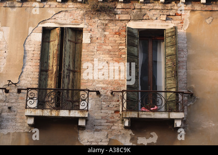 Windows with balconies on the side of a house  showing erosion from salt water and wind Stock Photo