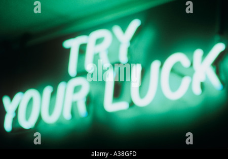 Defocussed green neon sign challenging public Try your Luck Stock Photo