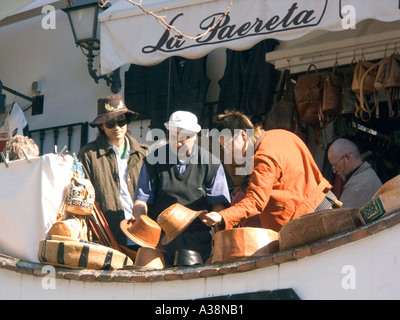 People choosing hats, Lather Goods for sale, Mijas Pueblo, Andalucia, Spain, Europe, Stock Photo