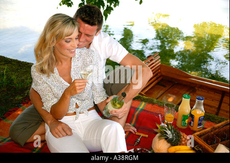 Verliebtes Paar bei einem Picknick am See, amorous couple having a picnic by the lake Stock Photo