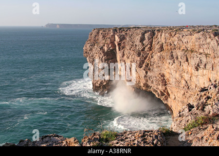 high cliffs at the headlands within the Fortress of Sagres Cape St. Vincent lighthouse in the background Algarve Portugal Stock Photo