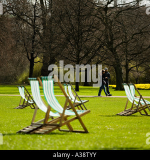 Green folding chairs in the sun at St. James Park London England UK