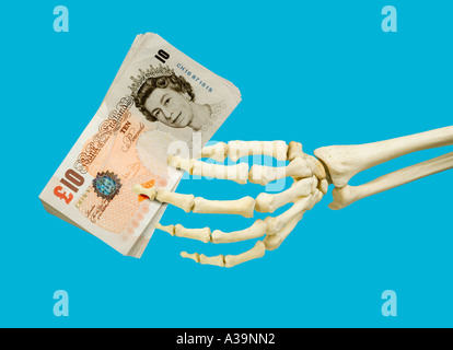 10 ten pound notes held in left skeleton hand Stock Photo