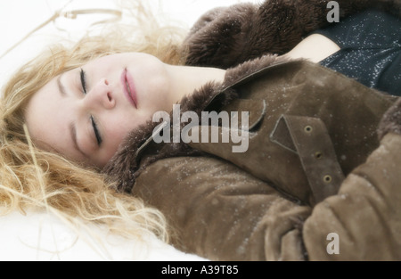 Sleeping woman in snow Stock Photo