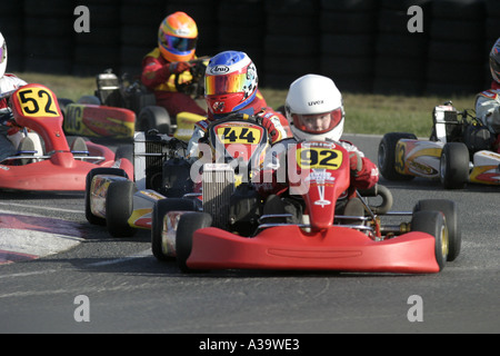 Colourful colorful mini max kart driver in the pack as the field goes round a corner Nutts Corner motorsport circuit Stock Photo