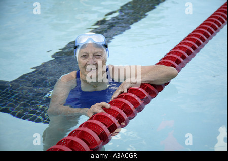 Senior woman preparing to swim laps, outdoor swimming pool. Stock Photo