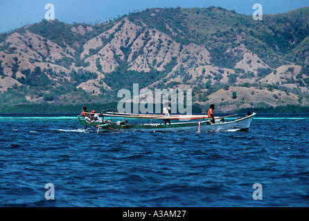 Outrigger canoe in the straits between Flores and Sumbawa near Pulau Rinca off Flores Indonesia Stock Photo