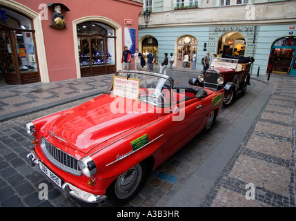CZECH REPUBLIC Bohemia Prague Old Town Tourists by old cars including red convertible Skoda used for city sightseeing tours. Stock Photo