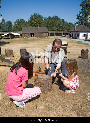 Children driving nails into wood with supervision Fort Langley national historical site Canada Stock Photo