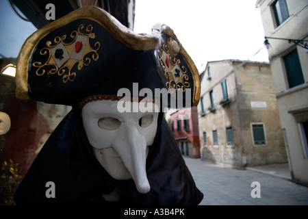 ITALY Veneto Venice Masked Carnival figure with long nose outside shop in deserted street in San Polo and Santa Croce District Stock Photo