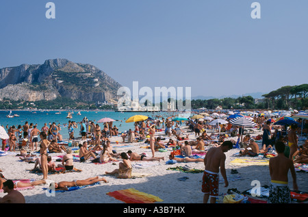 ITALY Sicily Palermo Mondello Beach Crowded with sunbathers on sand and view towards the sea and hills Stock Photo