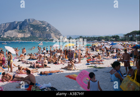 ITALY Sicily Palermo Mondello Beach Crowded with sunbathers on sand and view towards the sea and hills Stock Photo