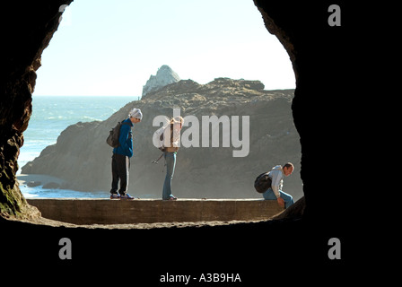 Tourists exploring a cave near a beach in San Francisco California USA Stock Photo
