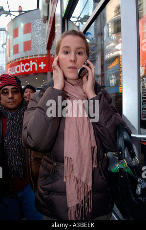 Woman speaks on her cellular telephone on the street in Times Square in NYC Stock Photo