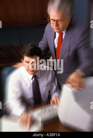 Two businessmen working on computer together blur Stock Photo