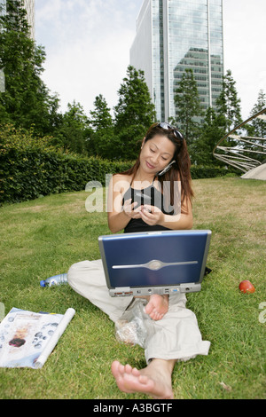 Asian girl on the telephone multitasking Stock Photo