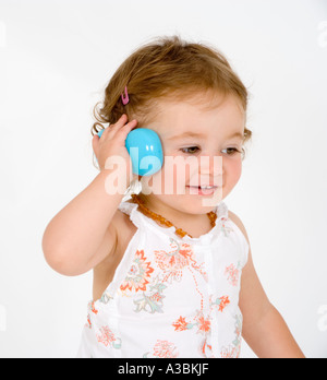 Female toddler (18-24 months) holding toy phone Stock Photo