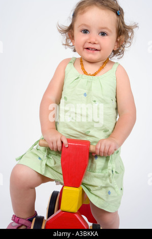 Toddler (18-24 months) riding wooden tricycle Stock Photo