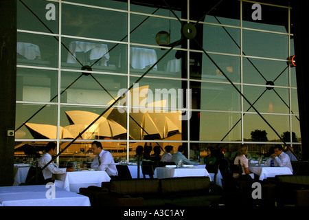Businessmen and other people eat a waterfront restaurant meal nearby the Sydney  Opera House Australia Stock Photo