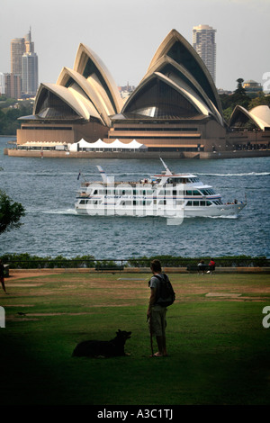 The Sydney Opera House on a beautiful day with Captain Cook cruises man and dog Stock Photo