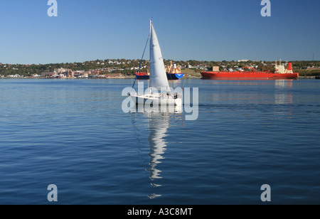 Sailboat with large steamship in the background Stock Photo