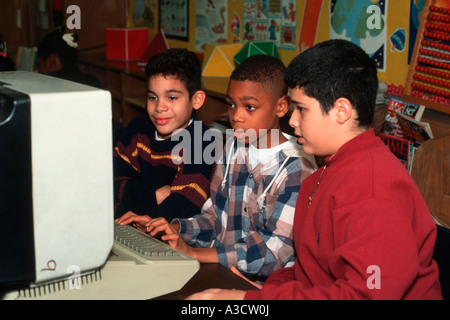 Boys work together at a computer terminal at an inner city school in Bushwick Brooklyn New York Stock Photo