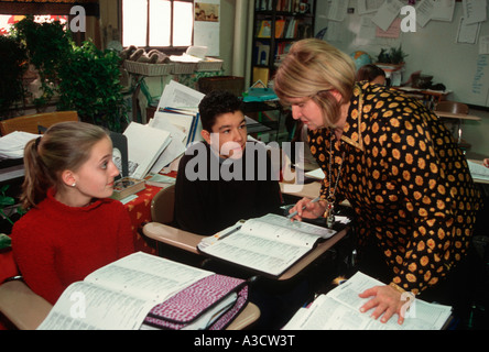 Junior high school teacher works with students in the classroom in New York City Stock Photo