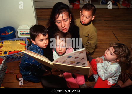 Nursery school teacher reads a story to a group of children at Free Space Nursery School in Park Slope Brooklyn NY Stock Photo