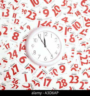 Conceptual image daily tear off calendar pages around clock face concept of busy appointment schedule time running out date to do deadlines planning Stock Photo