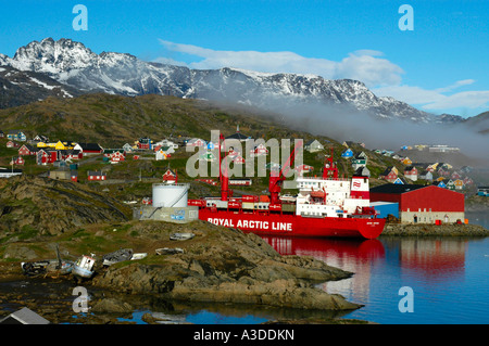 Container ship of Royal Arctic Line in the harbour of the city with colourful houses Ammassalik Eastgreenland Stock Photo
