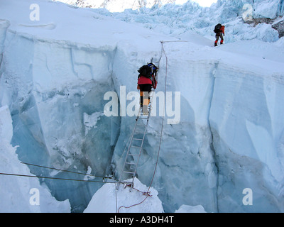 Viennese climber Geri Winkler on a ladder overcoming a crevasse of Khumbu Icefall, ca.5600 m, Mount Everest, Himalaya, Nepal Stock Photo