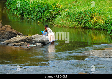 Woman doing laundry at the riverside, Mauritius Stock Photo