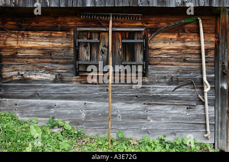 Scythe and a rake at a wooden wall of the Joser alp, Hochschwab mountain range, Styria, Austria Stock Photo