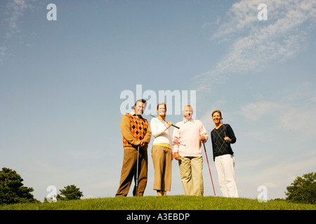 Portrait of two couples standing on a golf course Stock Photo