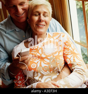 Senior woman listening to music with a mature man holding an Ipod Stock Photo