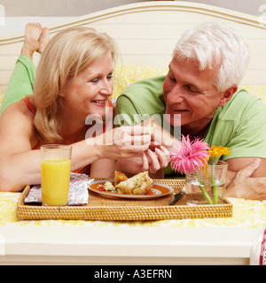 Mature couple having breakfast in bed Stock Photo