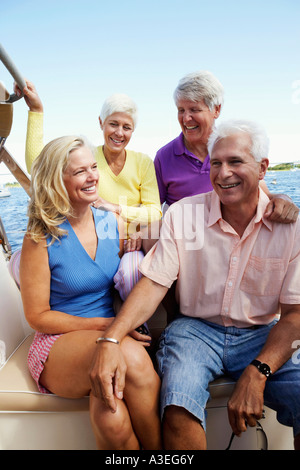 Close-up of two mature couples sitting in a boat and smiling Stock Photo