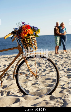 Close-up of a bicycle with a mature couple standing in the background Stock Photo