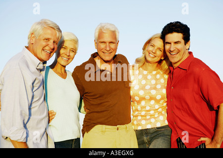 Portrait of three mature men and two mature women standing together and smiling Stock Photo