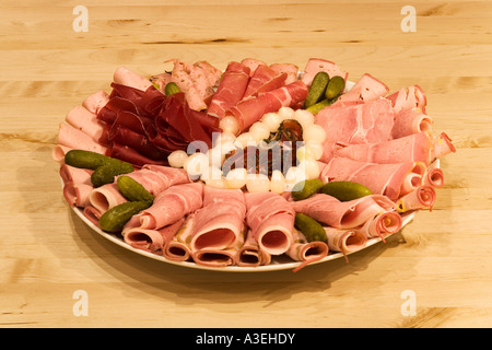Cold cut platter different sorts of sausage pearl onions and cucumbers Stock Photo